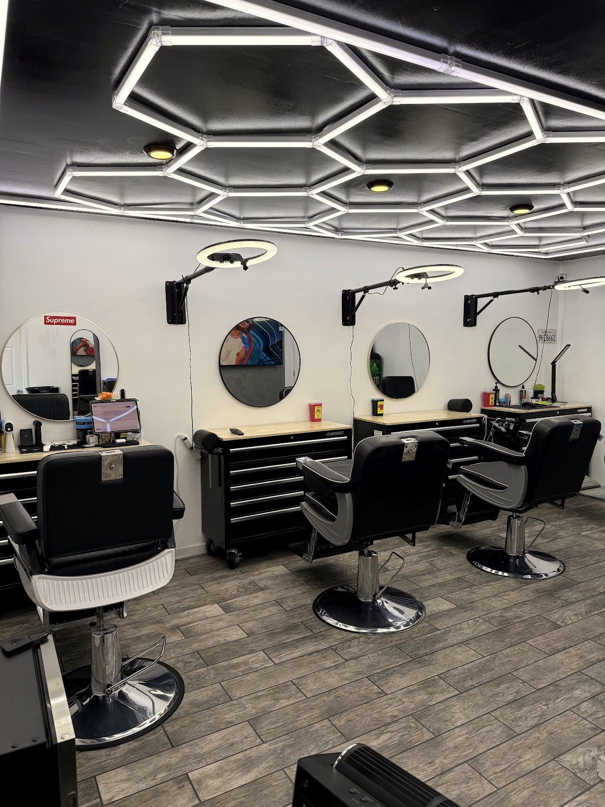 Inside The Angel Barbershop - black chairs and mirrors under the honeycomb ceiling